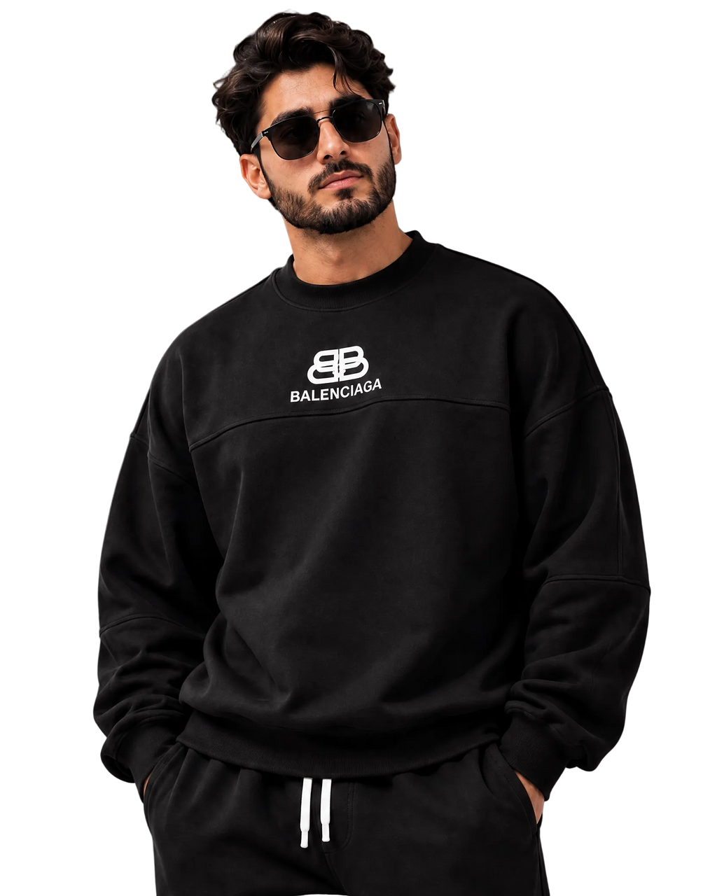 A man wearing a black Balenciaga crewneck sweatshirt and matching black sweatpants with white drawstrings, posed against a dark gray studio background.