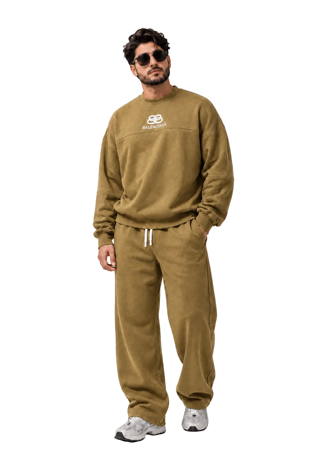 A man modeling a matching olive green sweatshirt and jogger pants set with white drawstrings and a white chest logo, styled with gray sneakers against a gray studio backdrop.