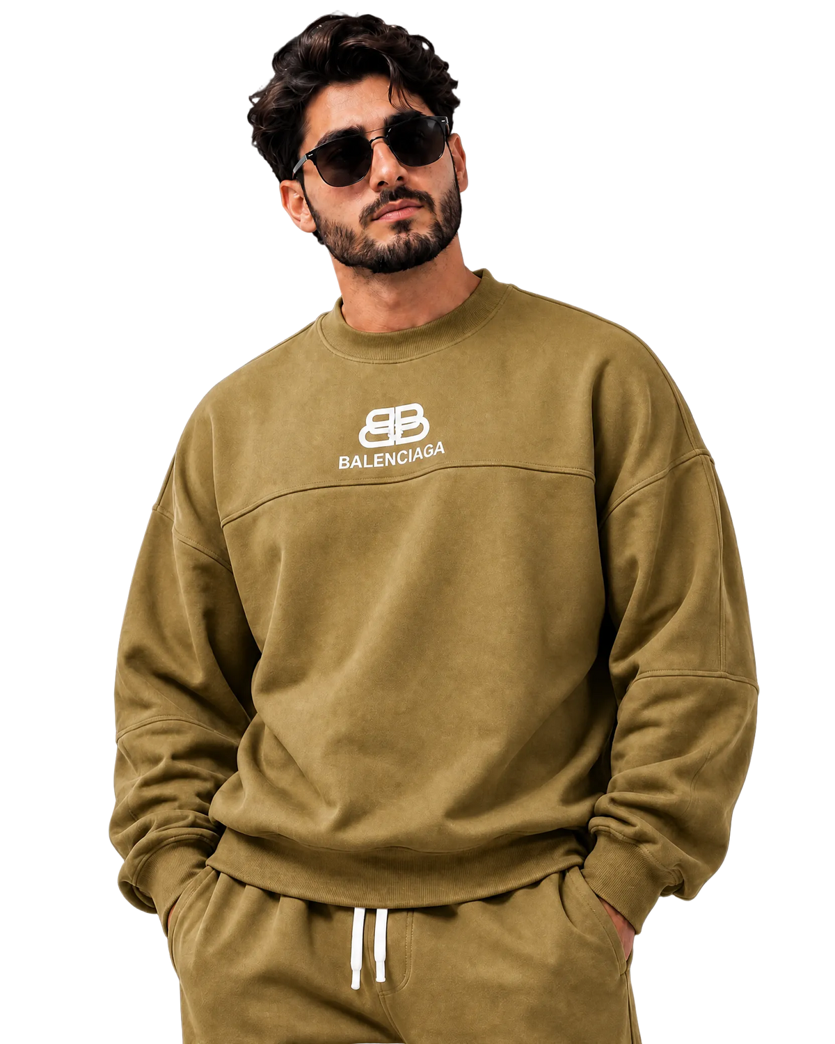 A man wearing a Balenciaga crewneck sweatshirt and matching sweatpants in olive green, styled with white drawstrings and sunglasses, against a dark gray studio background.