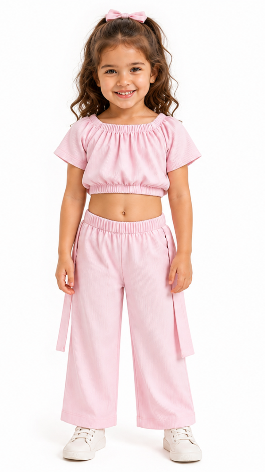 Young girl wearing a pink outfit with a matching top and pants on a white background