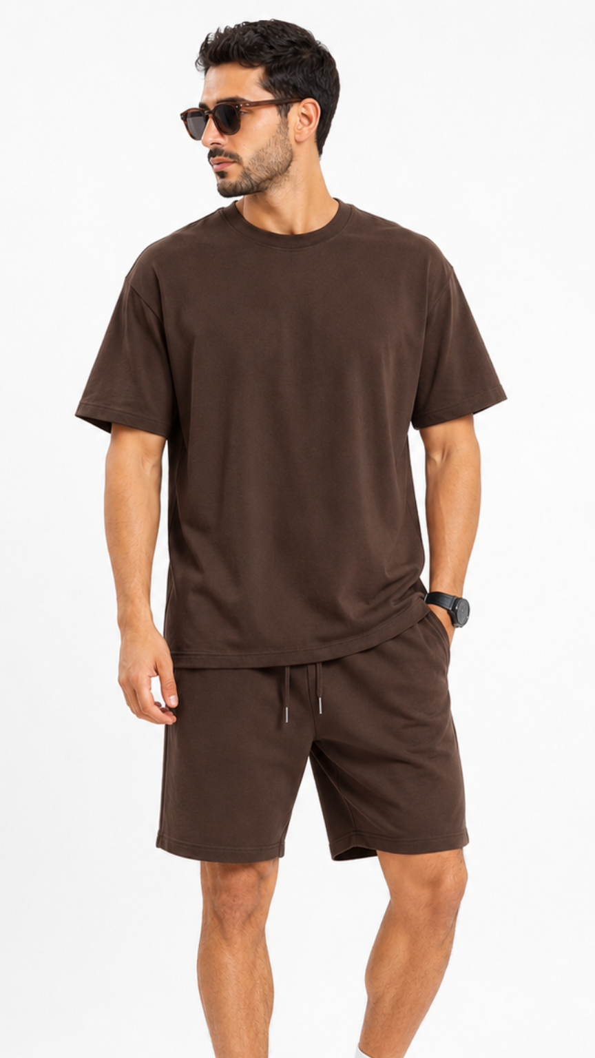 طقم رجالي كاجوال بلون بني شوكولاتة مكون من قطعتين: تيشرت قطني فضفاض (Oversized) بياقة دائرية وشورت متناسق برباط خصر، يظهر بتصميم عصري مريح على خلفية بيضاء.