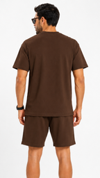 المظهر الخلفي لطقم بني (تيشرت وشورت) بقصة مريحة وبسيطة، يبرز جودة القماش واللون الموحد والتفصيل المتقن للأكتاف المنسدلة (Drop Shoulders).
