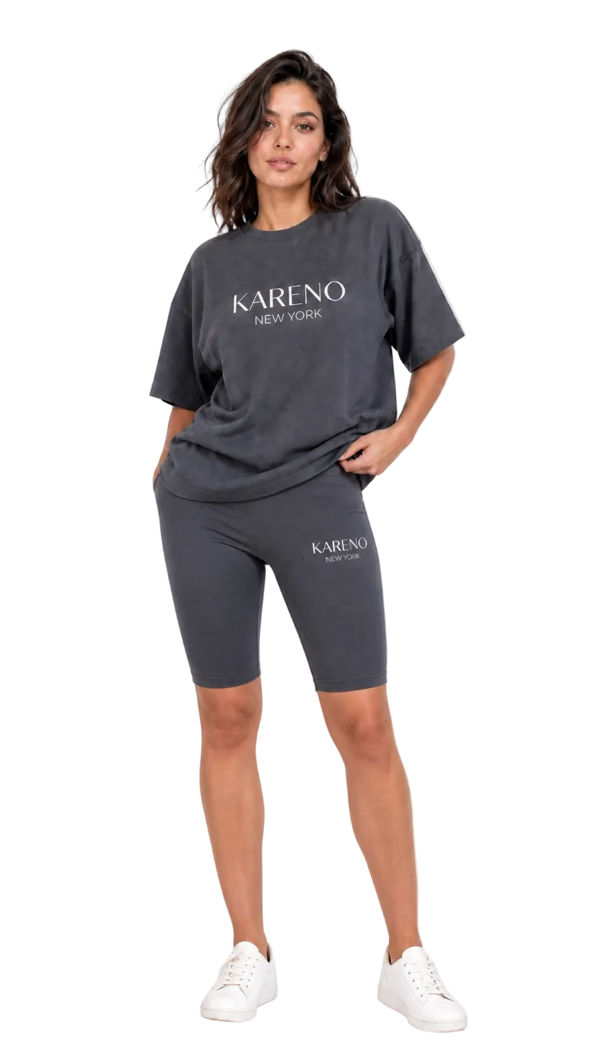 Woman wearing a dark gray 'Kareno New York' t-shirt and shorts on a white background