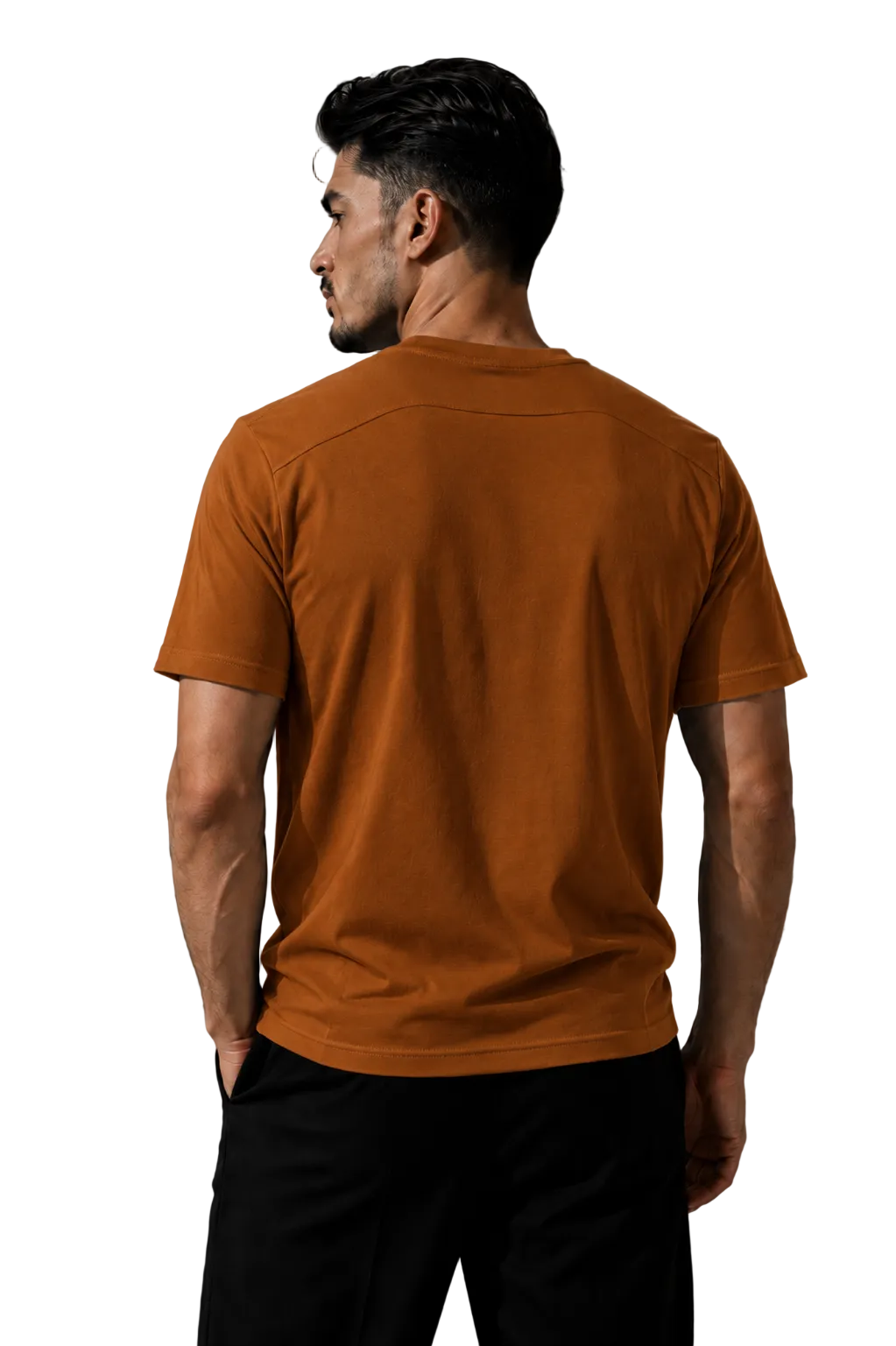 A man wearing a rust-orange short-sleeve t-shirt and black pants, shown from the back against a textured gray studio background.