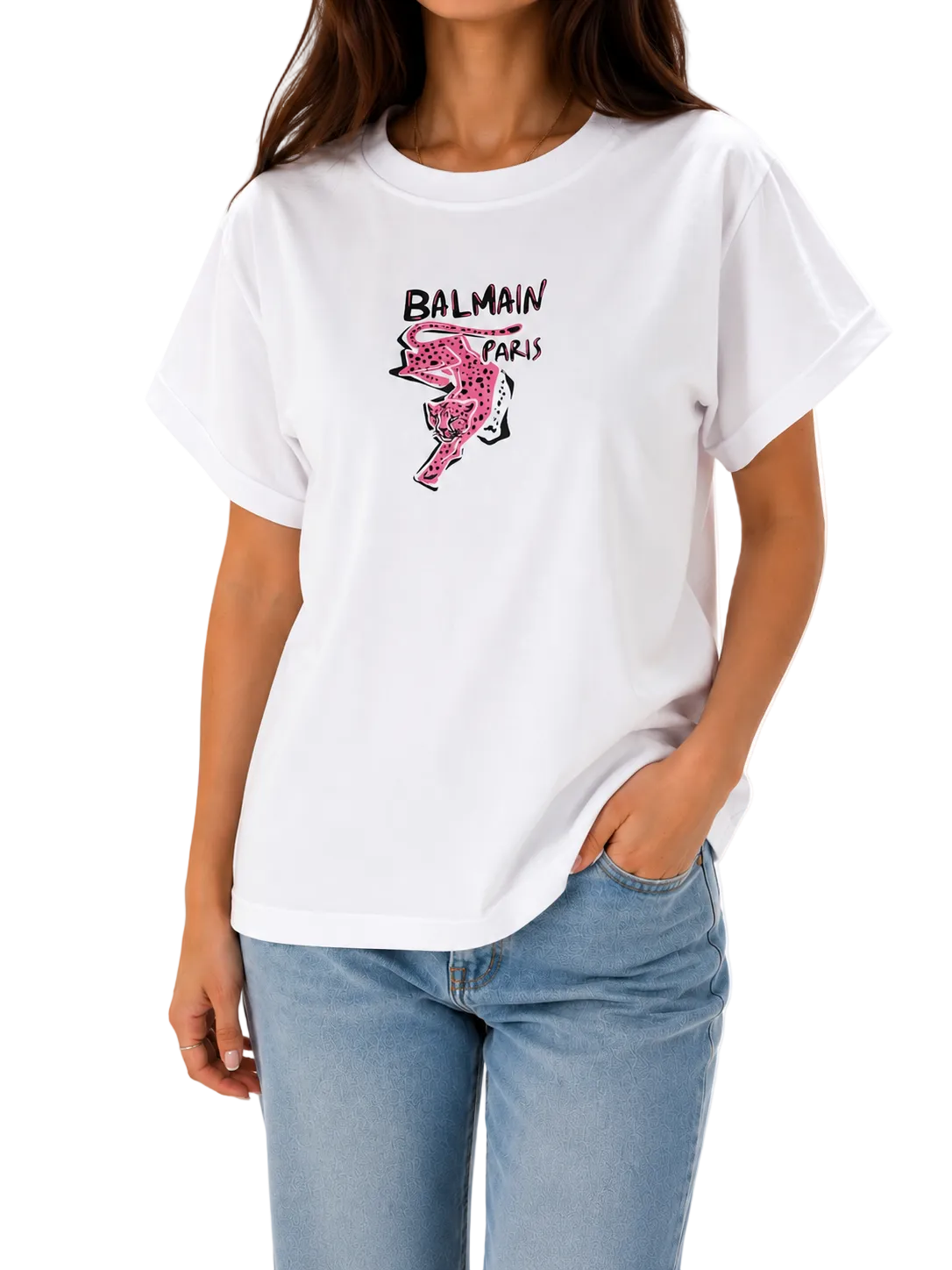 A woman wearing a white Balmain Paris graphic t-shirt with a pink flamingo print and black logo text, paired with light blue jeans, against a plain white background.