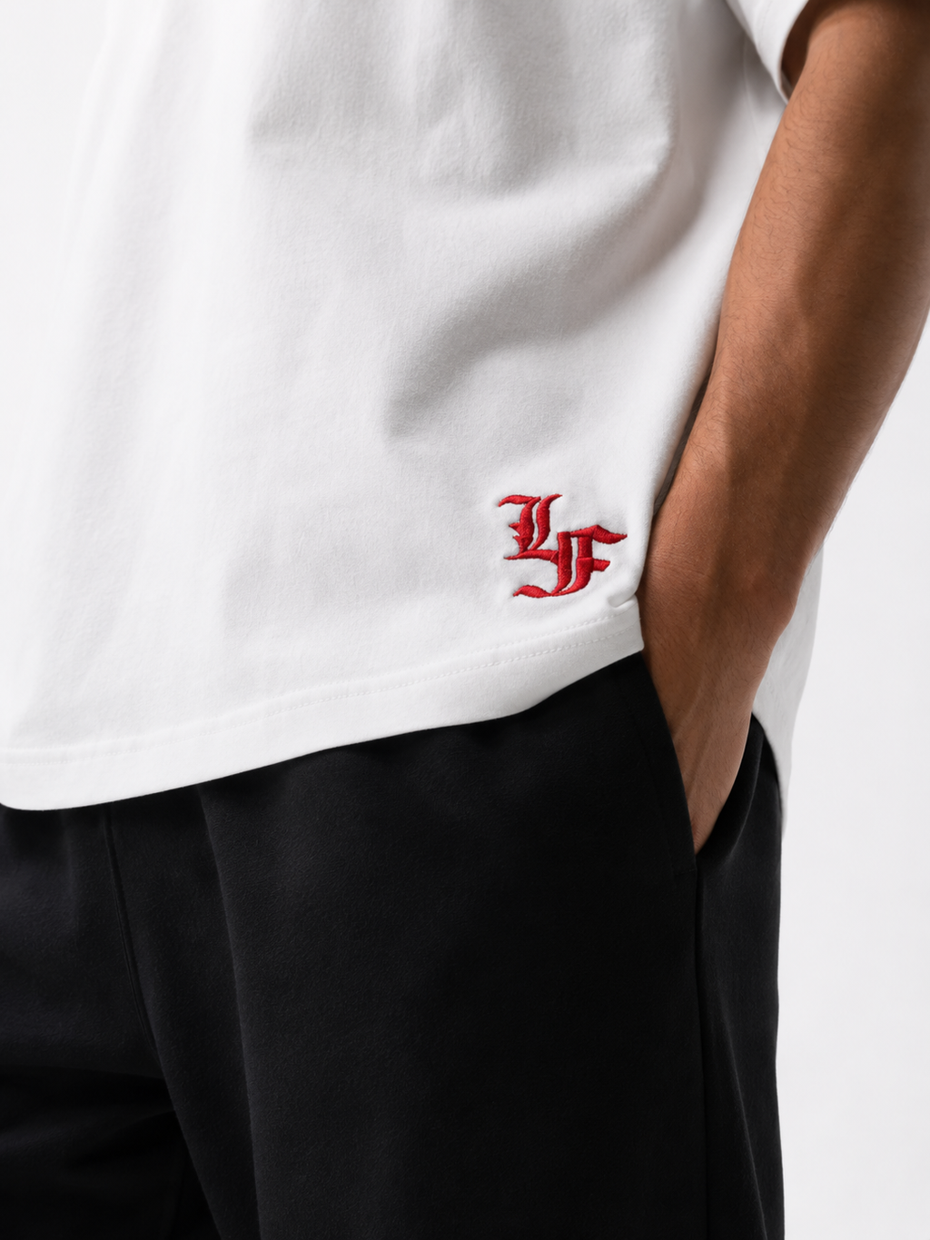 Male model wearing a white oversized premium cotton t-shirt with embroidered red LF logo on a clean white studio background.