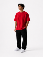 Male model wearing a red oversized premium cotton t-shirt with embroidered white LF logo on a clean white studio background.