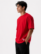 Male model wearing a red oversized premium cotton t-shirt with embroidered white LF logo on a clean white studio background.