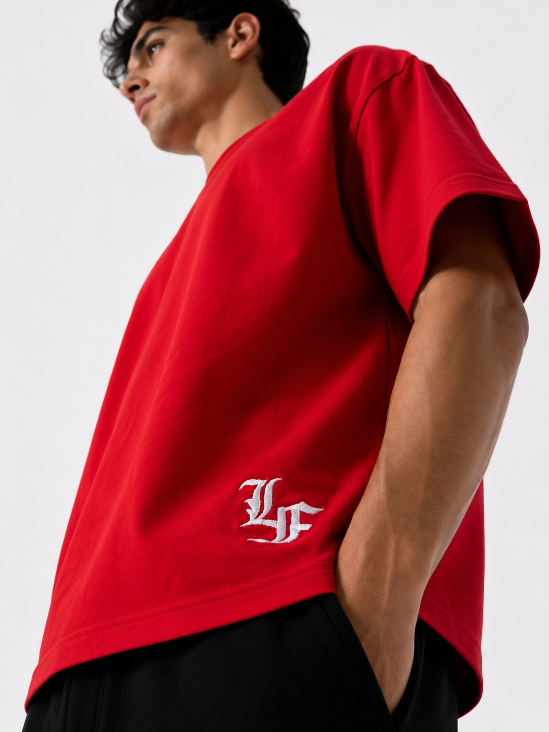 Male model wearing a red oversized premium cotton t-shirt with embroidered white LF logo on a clean white studio background.
