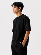 Male model wearing a black oversized premium cotton t-shirt with embroidered white LF logo on a clean white studio background.
