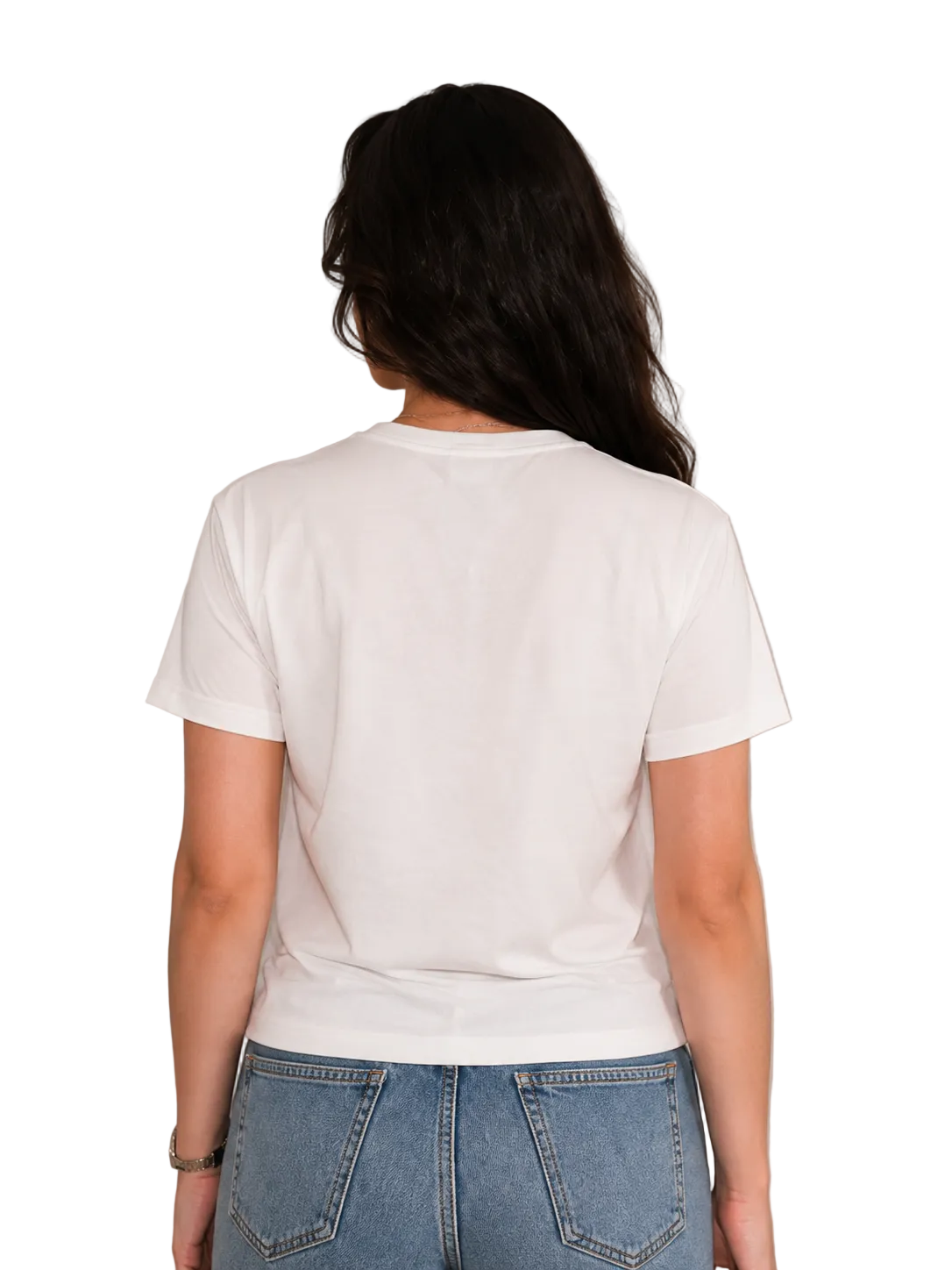 A woman viewed from behind wearing a plain white short-sleeve crewneck t-shirt and blue jeans, standing against a light beige paneled wall.