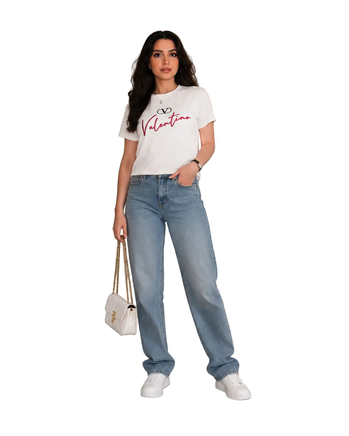 A woman stands in a studio setting wearing a white Valentino graphic T-shirt, light-wash wide-leg jeans, white sneakers, and holding a small white handbag.