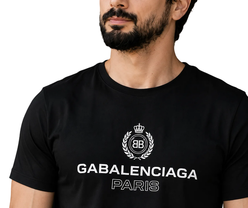 A close-up of a man wearing a black Balenciaga Paris t-shirt with a white printed logo and text on the chest.