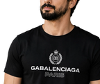 A close-up of a man wearing a black Balenciaga Paris t-shirt with a white printed logo and text on the chest.