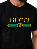 A close-up of a man wearing a black Gucci t-shirt featuring a large yellow 'GUCCI' logo and the iconic green and red web stripe with a yellow interlocking GG logo on the chest.