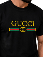 A close-up of a man wearing a black Gucci t-shirt featuring a large yellow 'GUCCI' logo and the iconic green and red web stripe with a yellow interlocking GG logo on the chest.