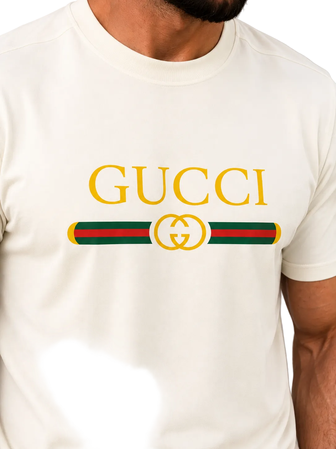 A close-up of a man wearing a cream-colored Gucci t-shirt with the brand's signature green and red web stripe and gold logo printed on the chest.
