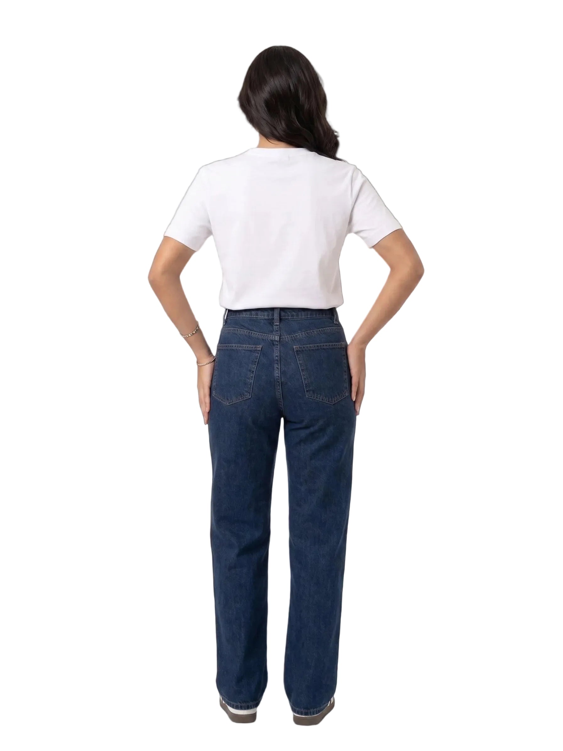 A woman viewed from behind wearing a white short-sleeve t-shirt and dark blue straight-leg jeans, standing against a plain white studio background.