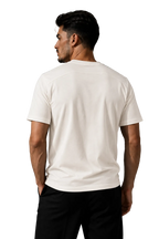 A man wearing a plain white short-sleeve t-shirt and black pants, shown from the back against a gray studio background.