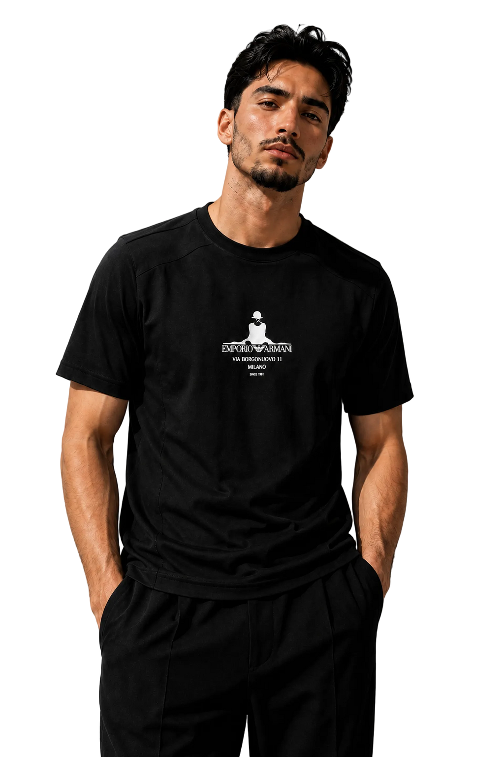 A man wearing a black short-sleeve t-shirt with a white graphic print on the chest, paired with black pants, standing against a textured gray wall.