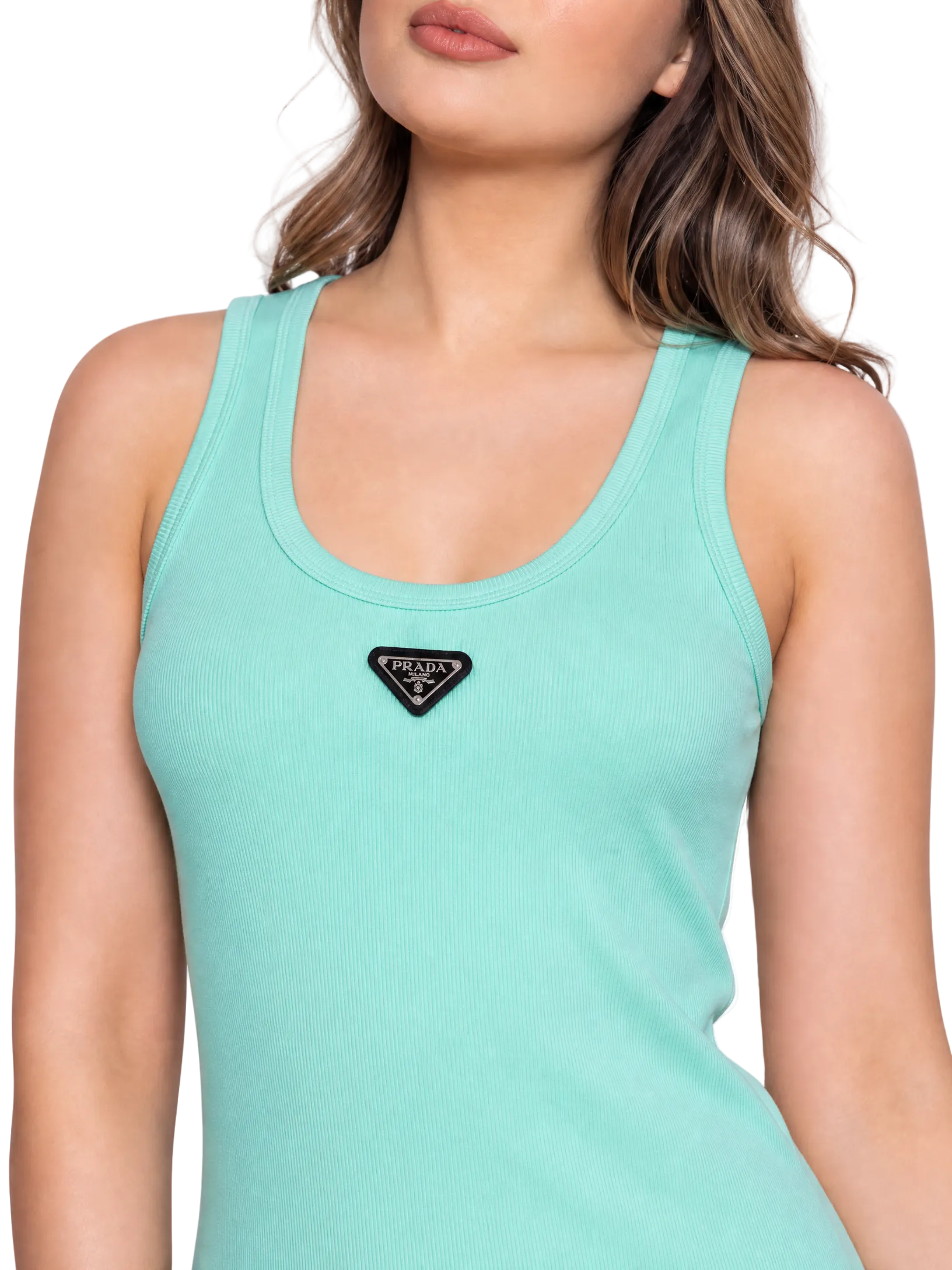 A close-up of a woman wearing a mint green ribbed tank top with a black triangular Prada logo patch on the chest, set against a plain white background.