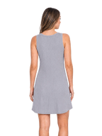 A woman viewed from the back wearing a sleeveless heather gray mini dress against a plain white studio background.