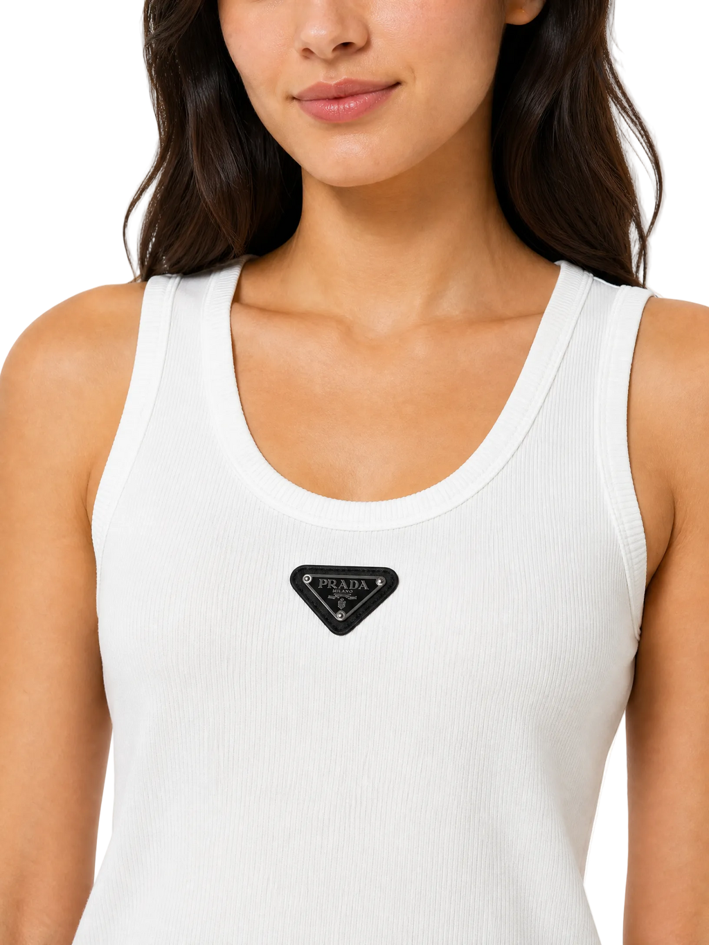 A close-up of a woman wearing a white ribbed tank top with a black triangular Prada logo patch on the chest, set against a plain white background.