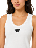 A close-up of a woman wearing a white ribbed tank top with a black triangular Prada logo patch on the chest, set against a plain white background.