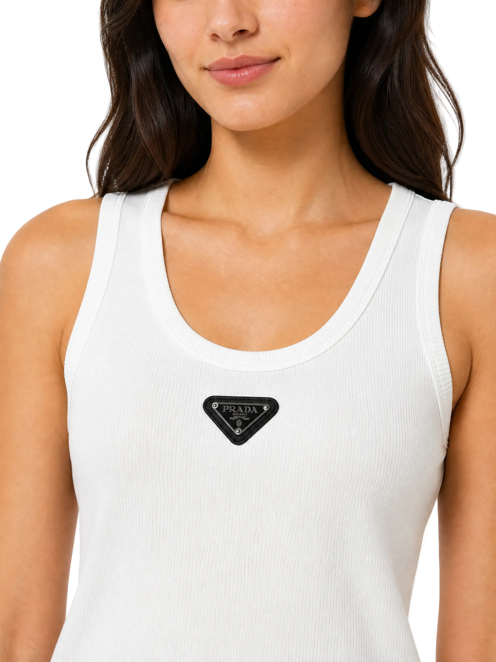 A close-up of a woman wearing a white ribbed tank top with a black triangular Prada logo patch on the chest, set against a plain white background.