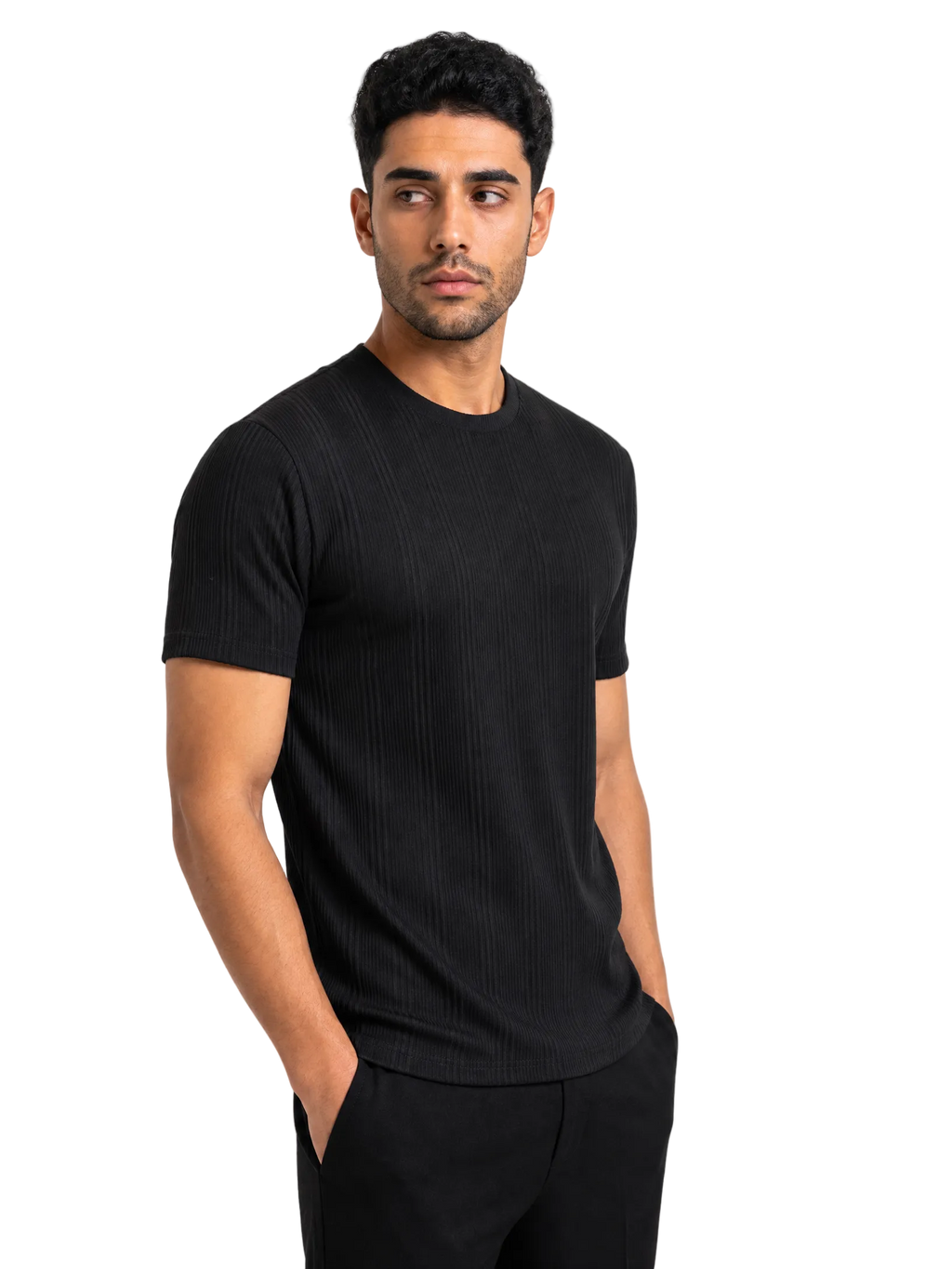 A man wearing a black short-sleeve ribbed crewneck t-shirt and black pants, standing against a solid white background.