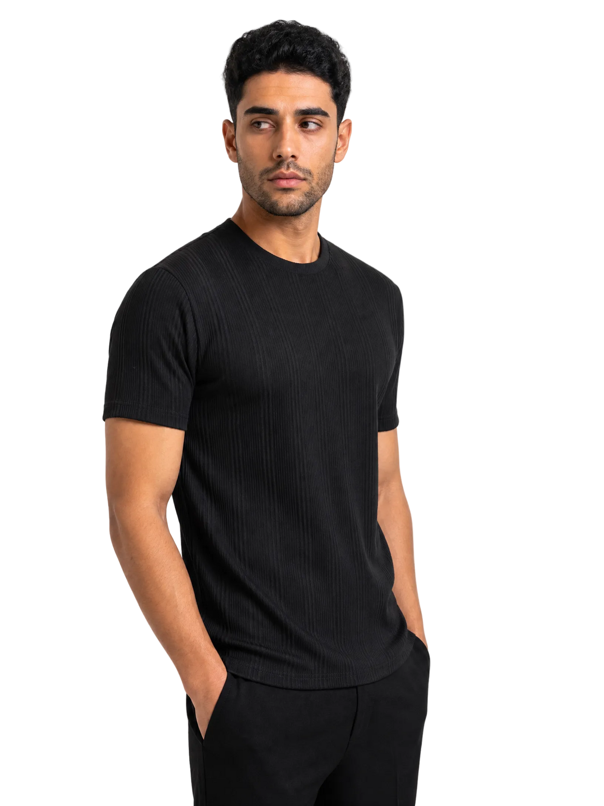 A man wearing a black short-sleeve ribbed crewneck t-shirt and black pants, standing against a solid white background.
