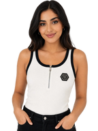 A woman modeling a white ribbed tank top with black trim, a half-zip neckline, and a black hexagonal logo patch on the left chest, paired with black jeans against a plain white background.