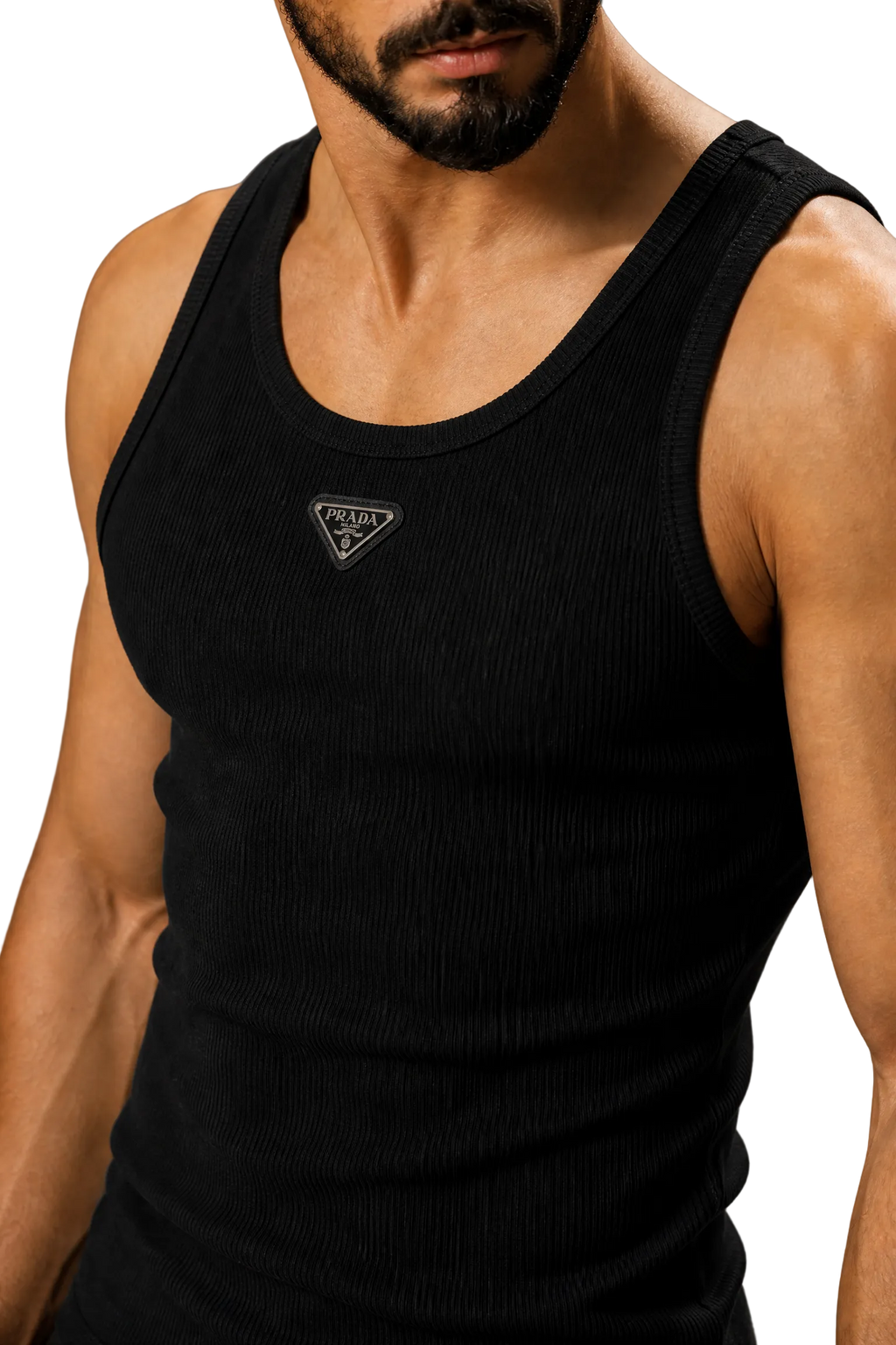 A close-up of a man wearing a black ribbed tank top with a small triangular logo patch on the chest, photographed against a neutral gray studio background.