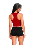 A woman shown from the back wearing a red racerback crop top and black athletic shorts against a plain light gray studio background.