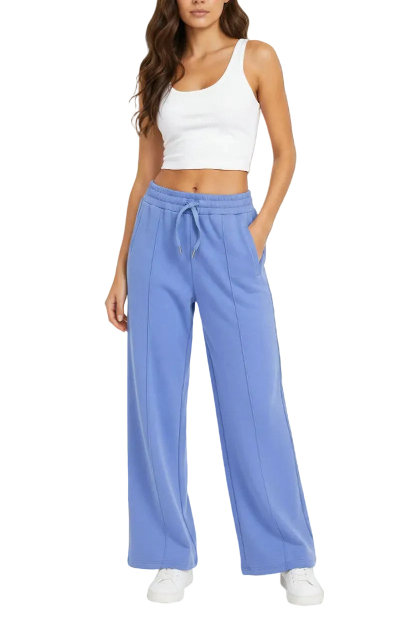 A model wearing light blue wide-leg sweatpants with a matching drawstring waistband and a white ribbed crop top, shown from the chest down against a plain off-white background.