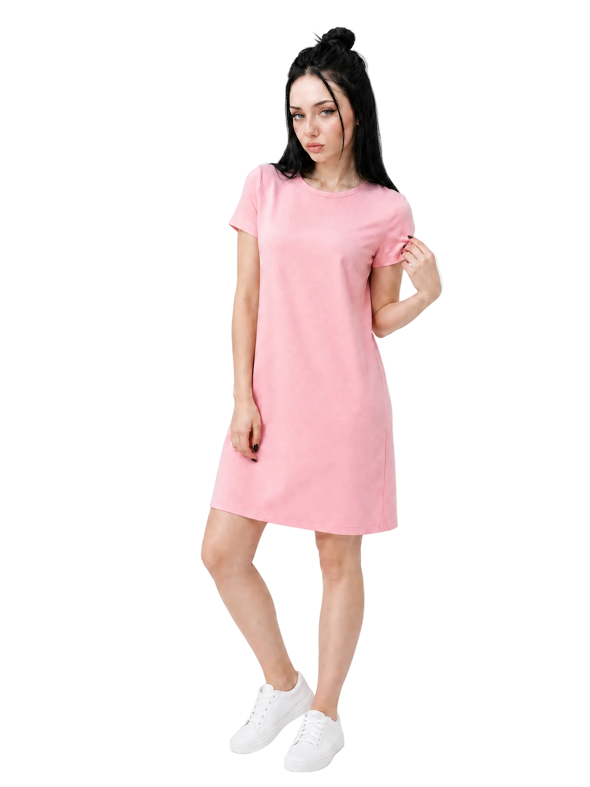 A woman modeling a light pink short-sleeve t-shirt dress with white sneakers, standing against a plain white studio background.