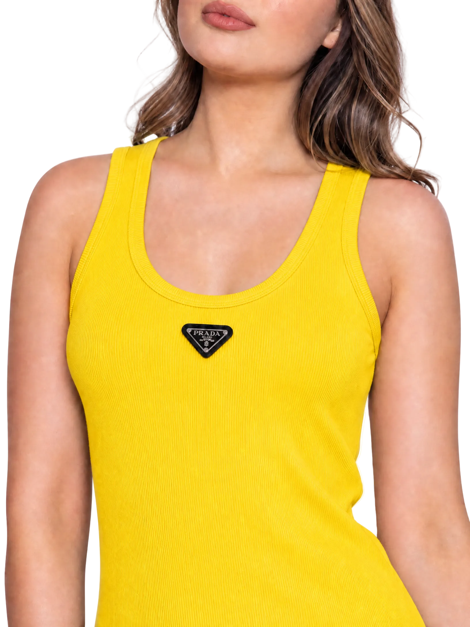 A close-up of a woman wearing a bright yellow ribbed tank top with a black triangular Prada logo patch centered below the neckline, against a plain white background.